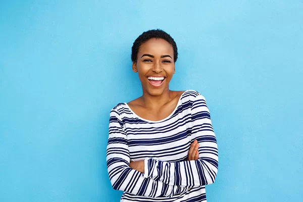 young lady folding her arms while smiling brightly