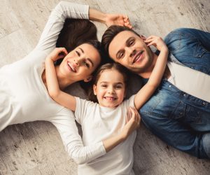 family of three on ground looking up